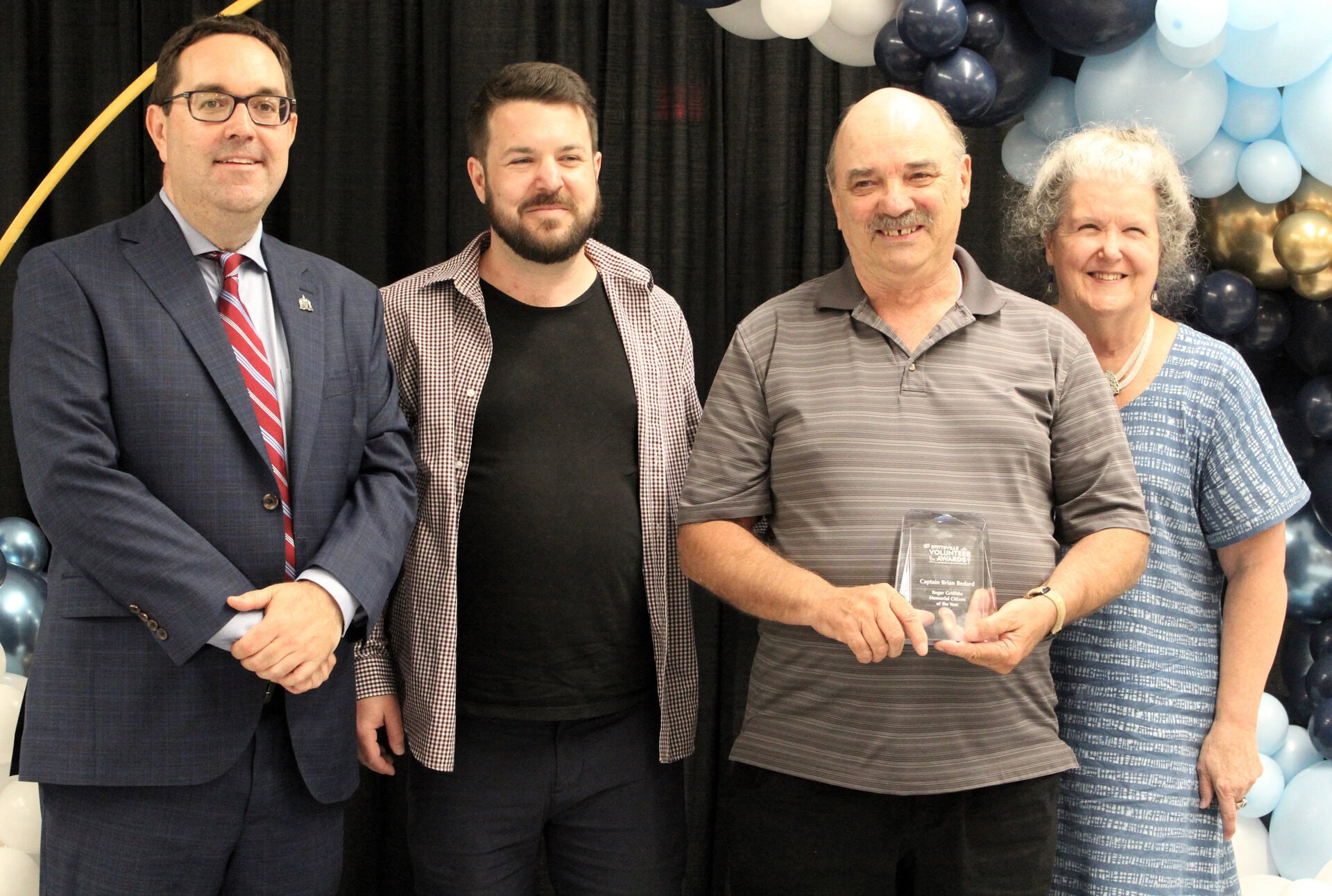 Captain Bedard receives the 2023 Roger Griffiths Memorial Citizen of the Year Award, presented by the Roger McKee and Lynn Griffiths, representing the Griffiths family.