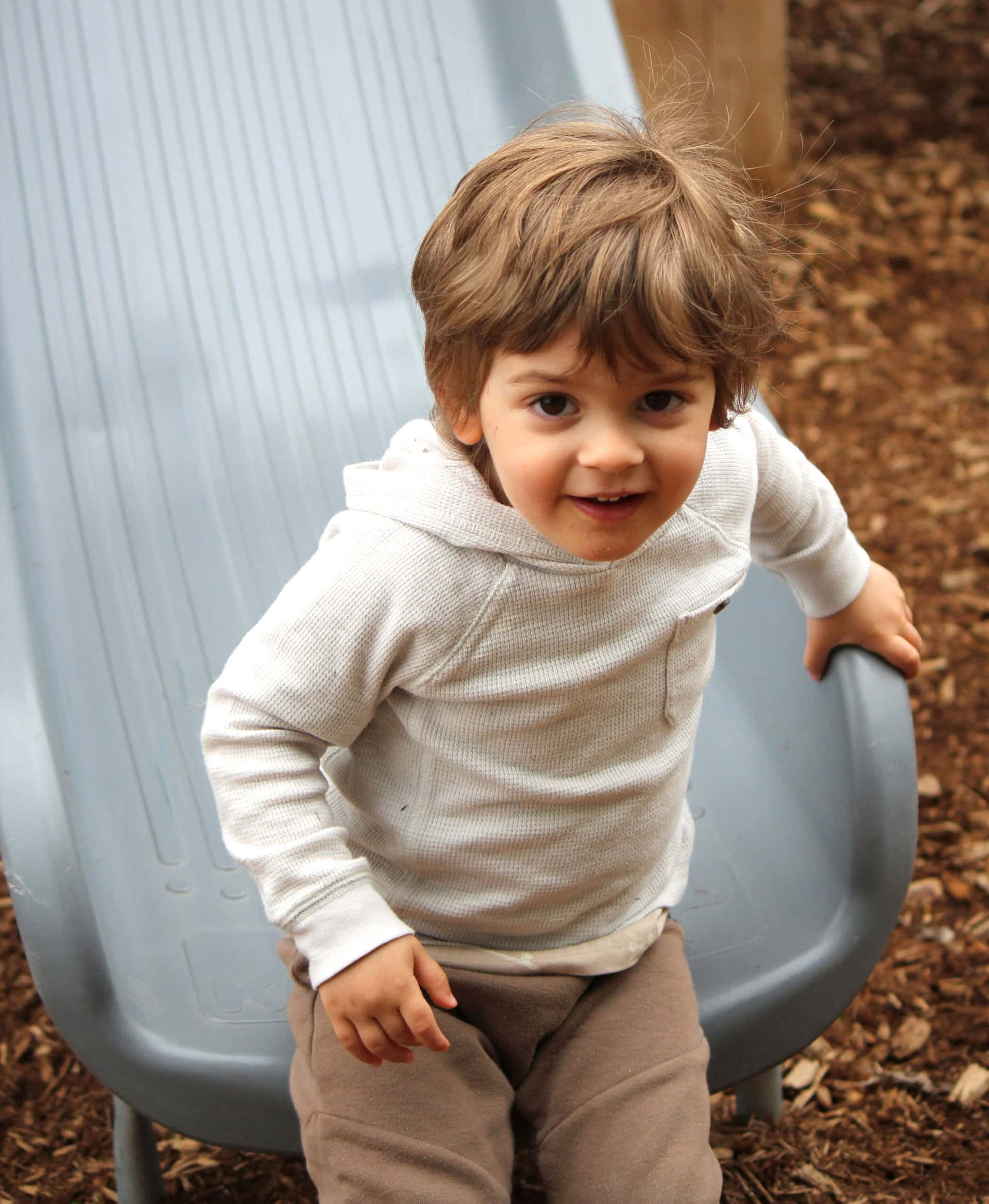 A kid goes down the slide at Village Square Park